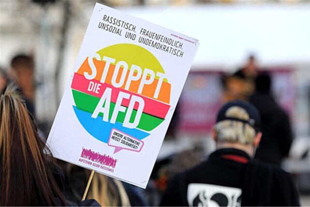 Eine Demonstrantin hält ein Plakat mit der Aufschrift „Stoppt die AfD“ (Archivbild).