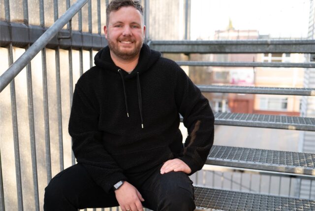 Benjamin Lehmkühler, FDP-Direktkandidat im Wahlkreis Unna I bei der Bundestagswahl, sitzt auf einer Treppe.