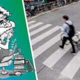 Ein Mann schiebt sein Fahrrad über den Zebrastreifen.