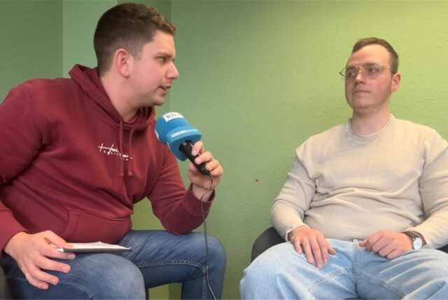 Nico Ebmeier spricht in ein Mikro, Benedikt Iwen hört zu.