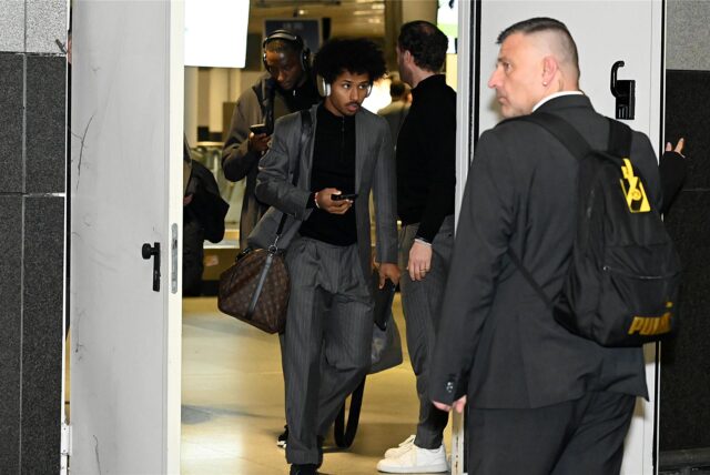 Karim Adeyemi hält sein Handy in der Hand.
