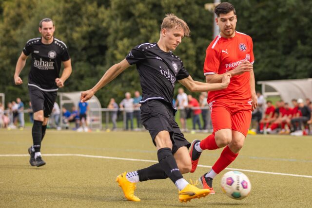Zwei Fußballspieler gehen in den Zweikampf.