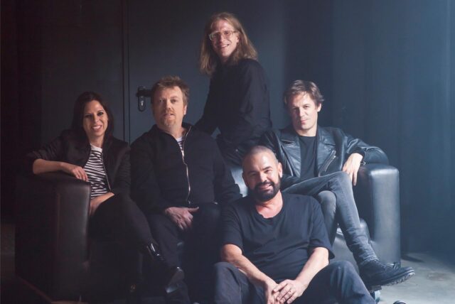 Die Band Alphaville sitzt auf einer schwarzen Couch