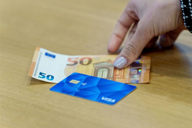 Eine Bezahlkarte und ein 50-Euro-Schein liegen auf einem Tisch.