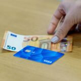 Eine Bezahlkarte und ein 50-Euro-Schein liegen auf einem Tisch.