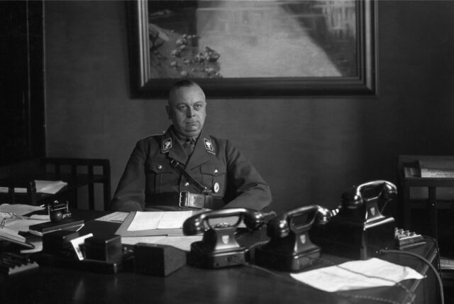 Wilhelm Schepmann in SA-Uniform als Polizeipräsident an seinem Schreibtisch.