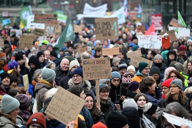 Demonstranten mit Schildern und Plakaten auf einer Demo für mehr Klimaschutz.