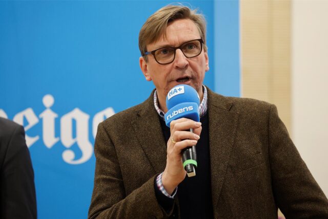 Michael Sacher von den Grünen spricht in einem Raum in Unna in ein Mikrofon.