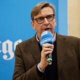 Michael Sacher von den Grünen spricht in einem Raum in Unna in ein Mikrofon.
