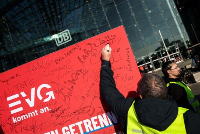 Ein Mann unterzeichnet ein Plakat.
