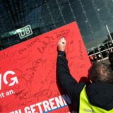 Ein Mann unterzeichnet ein Plakat.