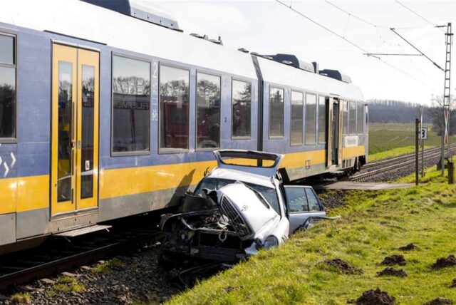 Ein zerstörter Mercedes liegt neben einer Regionalbahn. Beim Zusammenstoß eines Zuges mit einem Auto an einem Bahnübergang in Moers-Repelen wurde der Autofahrer lebensgefährlich verletzt.
