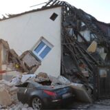 Vor einem eingestürzten Haus steht ein Cabrio. Einsatzkräfte sind vor Ort.