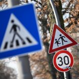 Ein Schild weist auf eine 30er-Zone und Kinder hin. Im Vordergrund ist ein Schild für einen Zebrastreifen zu sehen.