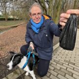 Der Unnaer Heiko Liedtke hält in einer Hand einen schwarzen Plastikbeutel. Mit der anderen hält er seinen Hund an der Leine.