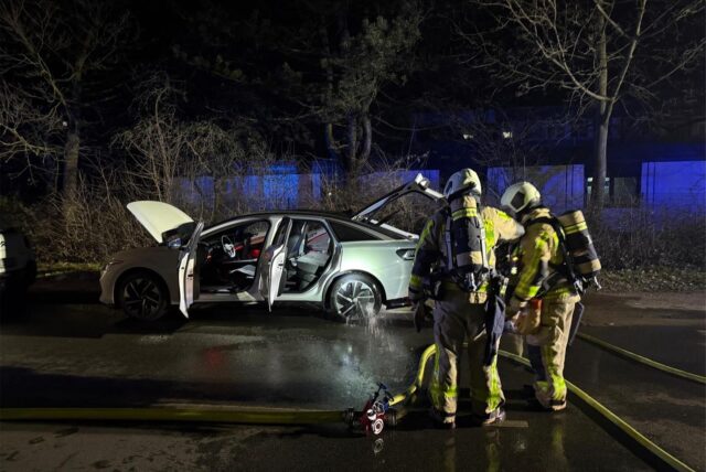 Ausgebranntes Auto steht auf einer Straße.