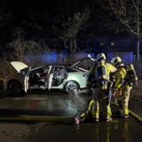 Ausgebranntes Auto steht auf einer Straße.
