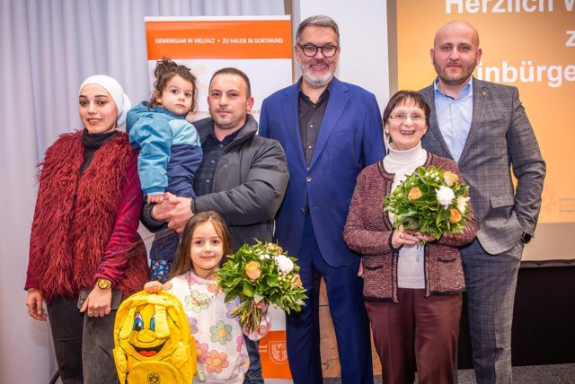 Oberbürgermeister Thomas Westphal und Leonid Chraga (re), Vorsitzender des Integrationsrats begrüßen neu eingebürgerte Dortmunder.