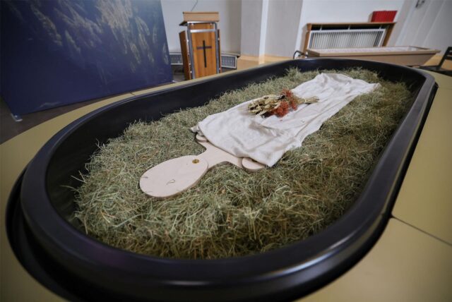 Zu sehen ist ein sargähnliches Gerät, in dem tote Körper in kompostierte Erde umgewandelt werden.