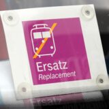 An einer Frontscheibe eines Busses hängt ein Schild, das ihn als Schienenersatzverkehr auszeichnet.