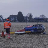 Einsatzkräfte gehen über ein Feld zu einem abgestürzten Kleinhubschrauber. Die zwei Insassen wurden bei dem Hubschrauberabsturz verletzt.