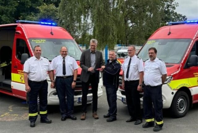 Bergkamens Bürgermeister Bernd Schäfer, Dirk Jürgens (stv. Wehrleiter), Bernd Externbrink (stv. Wehrleiter), Dirk Kemke (Wehrleiter), Ralf Klute (Einheitsführer Oberaden) und Marc Baginski (stv. Einheitsführer Mitte) stehen vor zwei neuen Einsatzwagen der Feuerwehr.