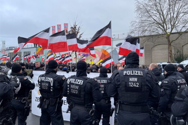 Polizeibeamte stehen von einer Demonstration von Rechtsextremen, die im Dezember 2024 durch Dortmund gezogen ist. Die Neonazis haben Fahnen mitgebracht.