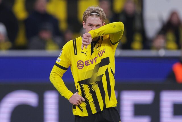 Julian Brandt wischt sich mit seinem linken Ärmel die Nase.