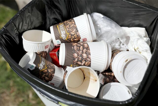 In einem Mülleimer liegen einige Einweg-Kaffeebecher
