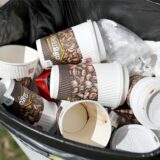 In einem Mülleimer liegen einige Einweg-Kaffeebecher