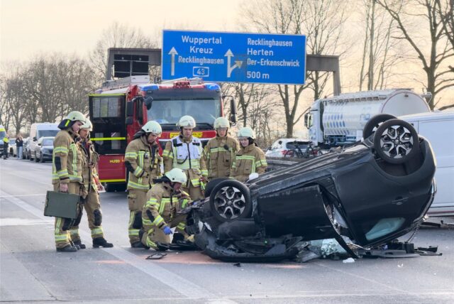 Feuerwehrfahrzeuge stehen auf der A43 bei Recklinghausen. Ein Kleinwagen liegt auf dem Dach. Feuerwehrkräfte stehen um das Fahrzeug herum.
