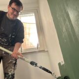 Robin Conrad streicht seine Wand grün.