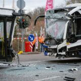 Polizisten stehen am Unfallort, nachdem zwei Linienbusse auf einer Kreuzung in Saarbrücken frontal zusammengestoßen sind.