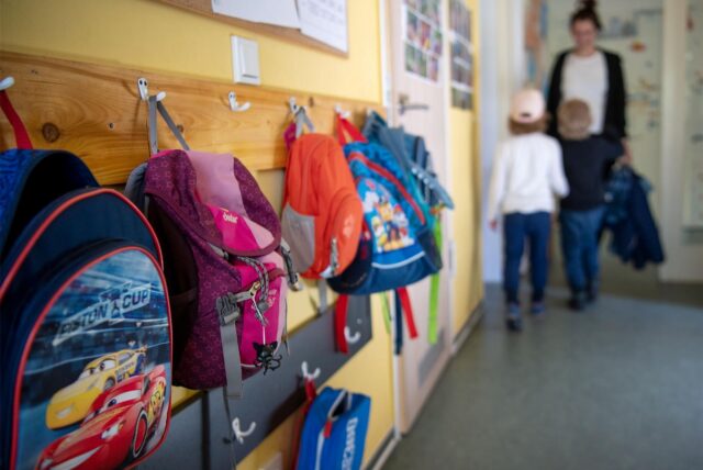 Rucksäcke hängen an einer Garderobe