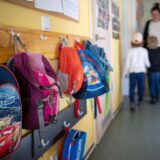 Rucksäcke hängen an einer Garderobe