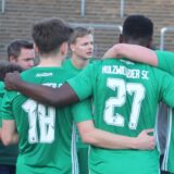 Die Spieler des Holzwickeder SC stehen im Herner Stadion im Kreis.