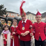 Der 90-jährige Karnevalist Helmut Scherer (M.) mit dem Kinderdreigestirn der Liedbachschule in Billmerich vor dem Eselsbrunnen auf dem Markt in Unna (von rechts nach links): Prinz Theo Lipkowski, Prinzessin Jette Chade und Antonia Koerdt von der Katharienschule, die für die erkrankte Präsidentin Nelly Kramer für das Foto eingesprungen ist.