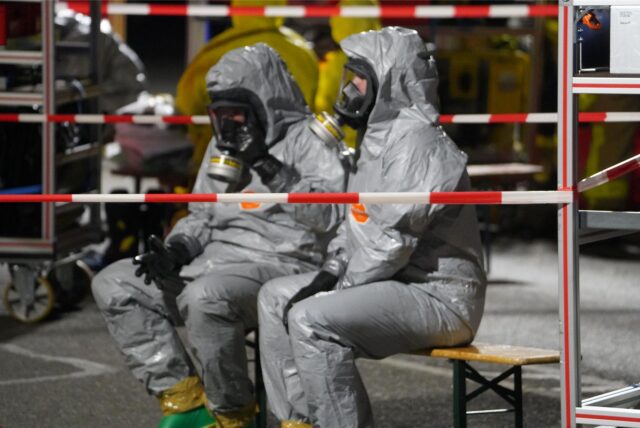Feuerwehrleute in Schutzanzügen und mit Gasmasken vor dem Motel de Winter in Ickern.