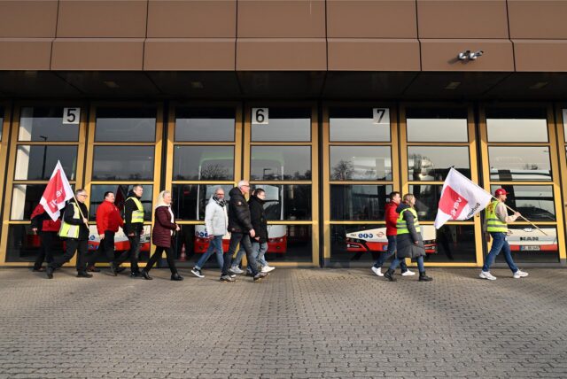 Mitarbeiter der Bogestra gehen auf dem Betriebshof Ückendorf mit Verdi-Fahnen an Bussen vorbei. Freitag ist ein Warnstreik angekündigt.