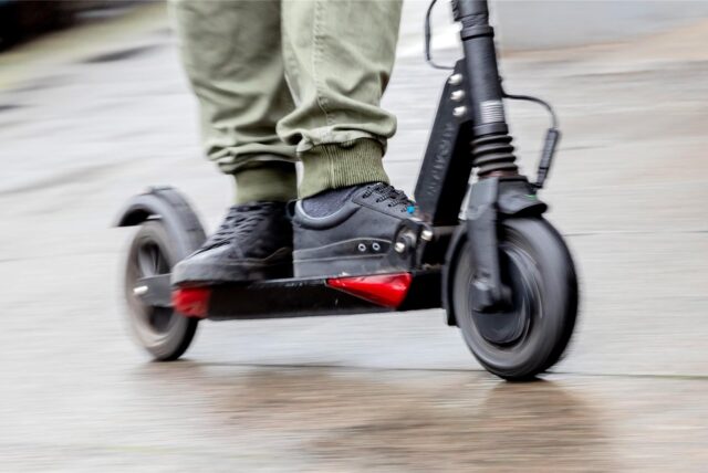 Ein Mann fährt mit einem E-Scooter