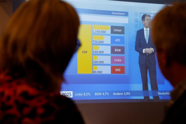Zwei Personen verfolgen im Kreishaus Unna am 23. Februar 2025 eine Sendung der ARD zur Bundestagswahl.