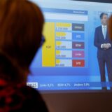 Zwei Personen verfolgen im Kreishaus Unna am 23. Februar 2025 eine Sendung der ARD zur Bundestagswahl.