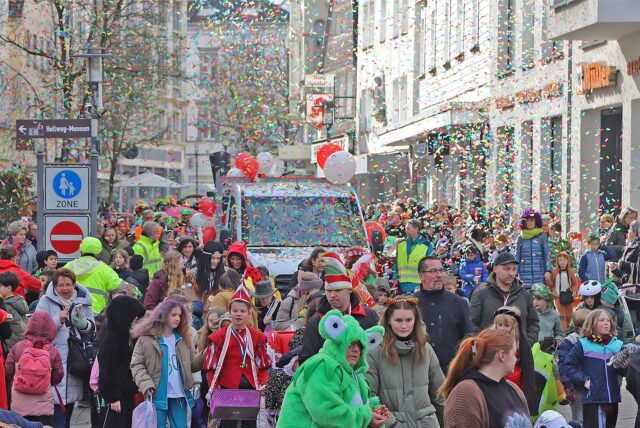 Auf dem Bild ist eine verkleidete Menschenmenge zu sehen, die gemeinsam durch die Unnaer Innenstadt zieht, um den Kinder-Karneval zu feiern.