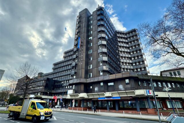 Ein Transporter der EDG fährt am früheren RAG-Hochhaus in Dortmund vorbei.