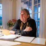 Der Trierer Rechtsanwalt Bernward Wittschier sitzt an einem Tisch hinter einem Aktenordner. Er leidet seid mehr als zehn Jahren an einer noch nicht diagnostizierten und fortschreitenden Krankheit.
