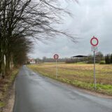 Totale auf die Wiesenstraße in Holzwickede. Die Straße geht zentral Richtung horizont, die alten Verkehrsschilder sind rechts im Bild.