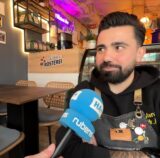Der Inhaber des neuen Cafés in Unna spricht in ein Mikrofon.