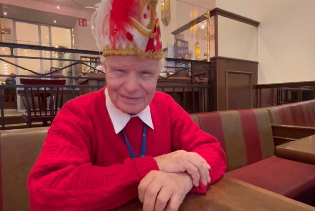 Der Unnaer Helmut Scherer (90) trägt während eines Interviews einen Orden und eine Narrenkappe