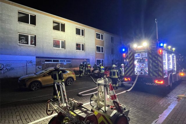 Feuerwehrleute stehen vor der Bauruine am Römerberg in Bergkamen-Oberaden. Im Inneren hatte es gebrannt.