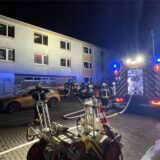 Feuerwehrleute stehen vor der Bauruine am Römerberg in Bergkamen-Oberaden. Im Inneren hatte es gebrannt.